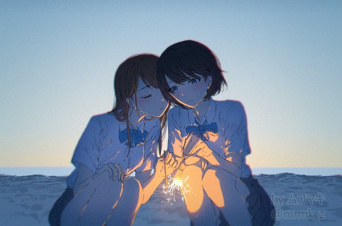 Two schoolgirls holding a sparkler at sunset