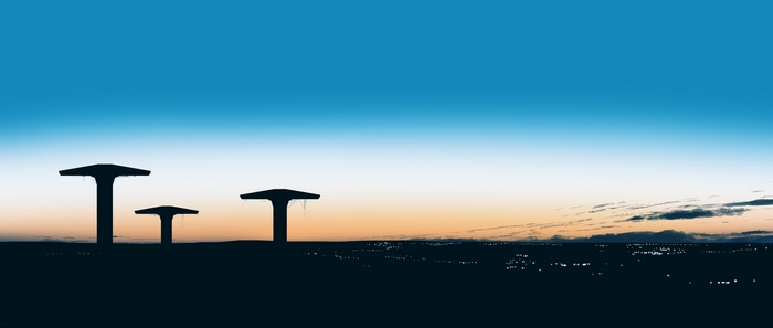 Silhouettes of structures against a sunrise sky