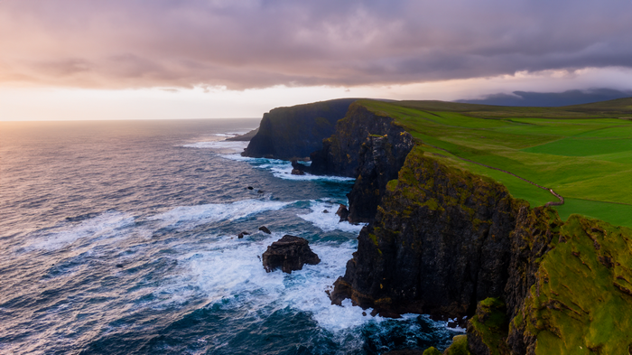 Dramatic sunset over the cliffs and ocean waves