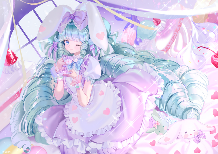 Girl with bunny ears drinking tea surrounded by sweets