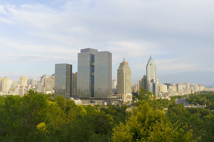 Urumqi skyline with modern skyscrapers and green trees