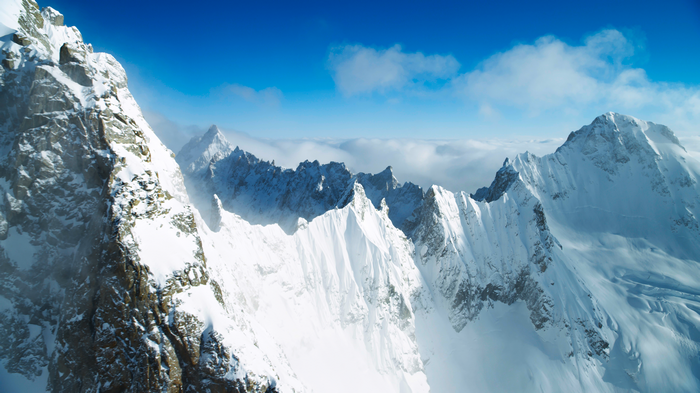 4K snow-covered mountains under a blue sky