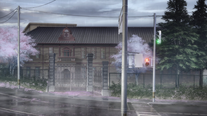 Anime screenshot of a school building on a rainy day