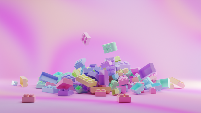 Colorful LEGO bricks scattered on a pink background