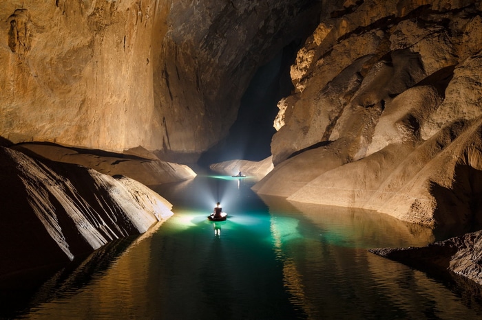 Two people in boats on a river inside Hang Son Doong cave, Vietnam