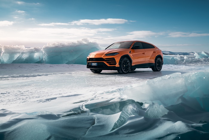 Orange Lamborghini Urus on icy landscape