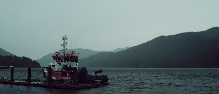 Boat docked at a pier with mountains in the background