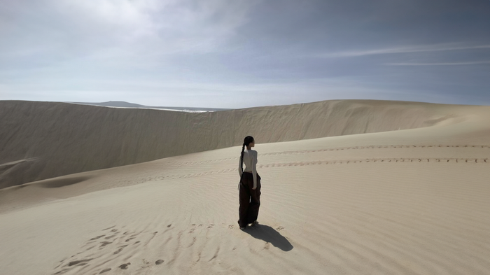 Woman with ponytail standing in a sand desert