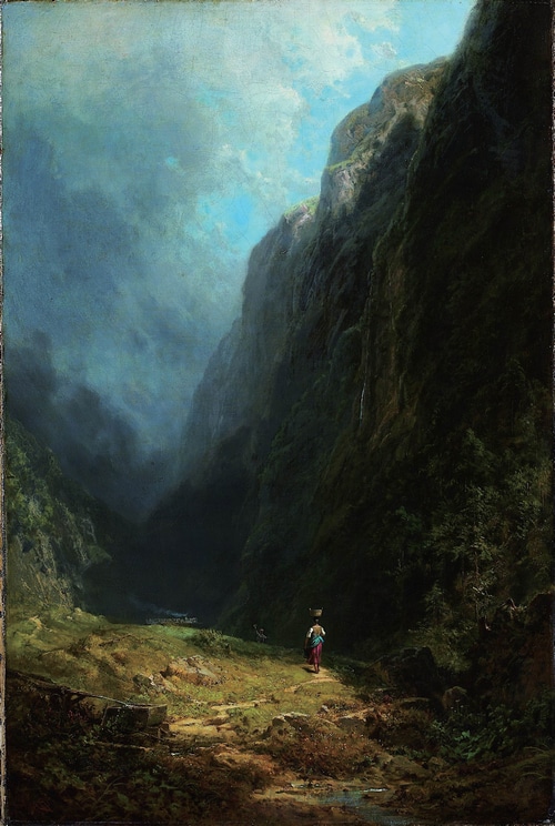 A person carrying a basket walks through a mountain valley