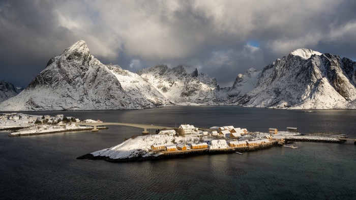 Snowy Lofoten village with mountains and fjord