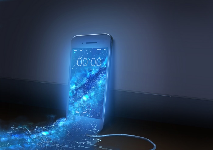 iPhone with galaxy wallpaper and charging cable