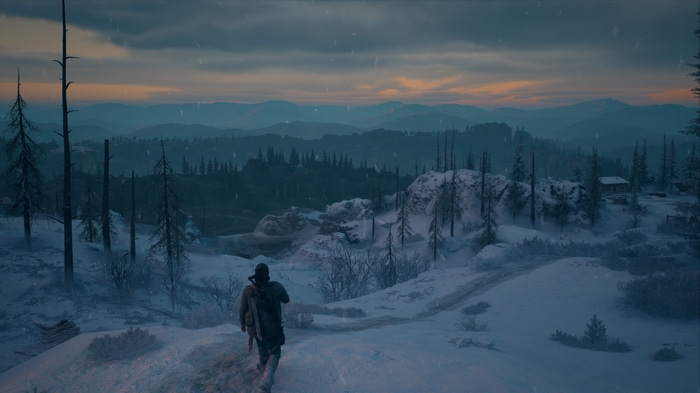 Deacon St John walks through a snowy mountain landscape in Days Gone