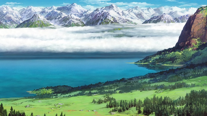Snow-capped mountains over a lake and green landscape