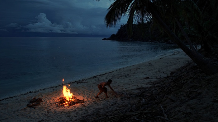 Tom Hanks on a beach with a bonfire in Cast Away
