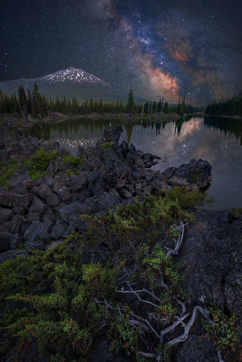 Milky Way over a lake with a snowy mountain peak