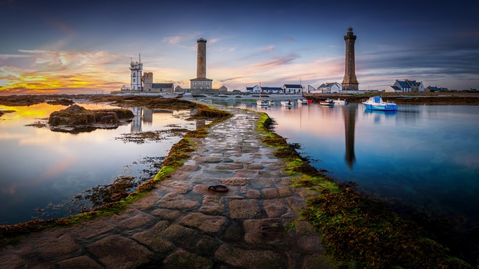 Lighthouse coast with stone path and sunset glow