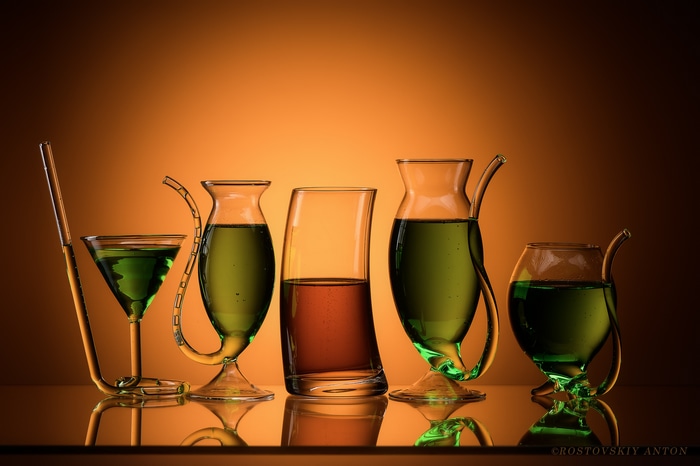 Five glasses with green and brown drinks