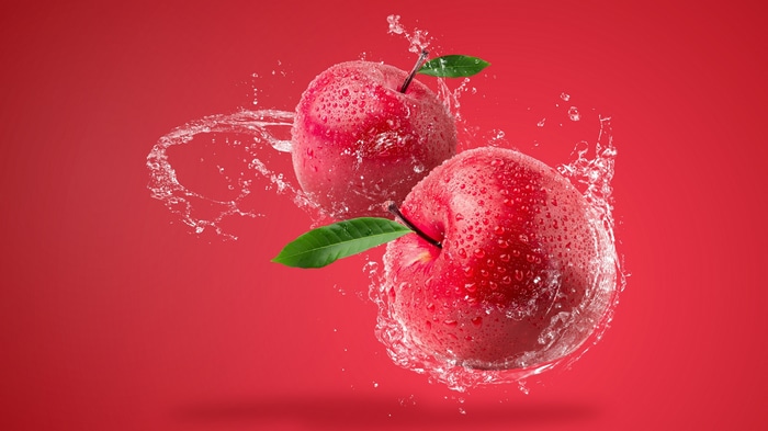 Two red apples with water splashes