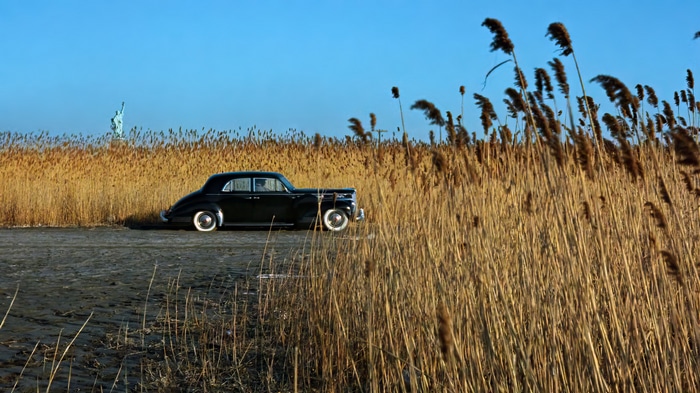 Black Packard car with Statue of Liberty in background