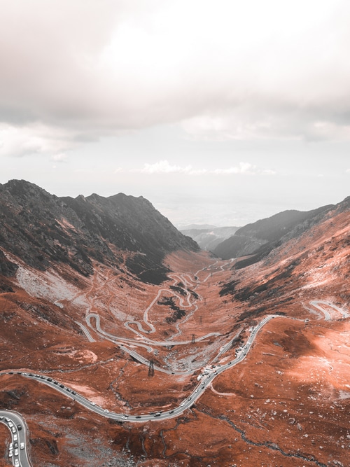 Aerial view of a winding mountain road with cars