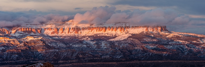 Sunset glow over snow-covered mountains in Bryce Canyon National Park