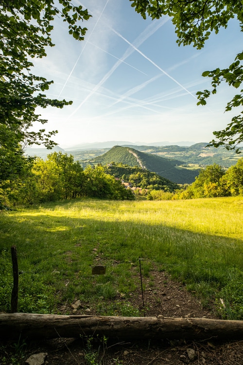 Green hills and sky with contrails