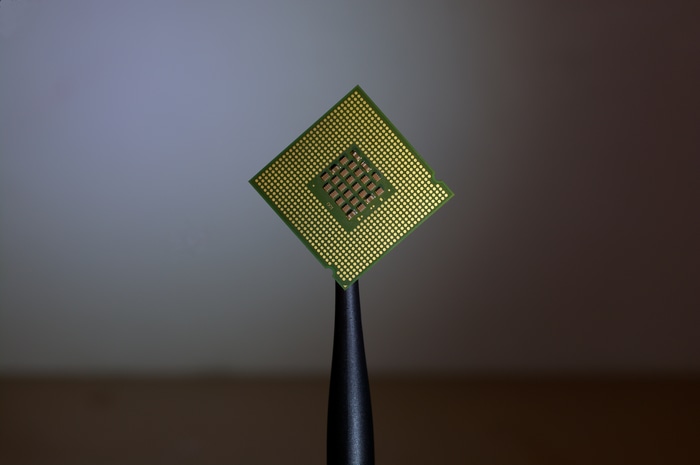 CPU microchip held by tweezers