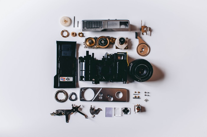 Disassembled camera parts laid out on a white background