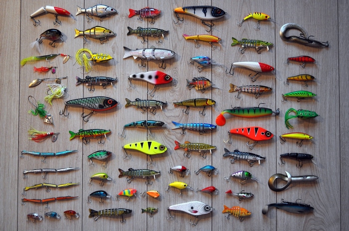 Collection of fishing lures and hooks on a wooden surface