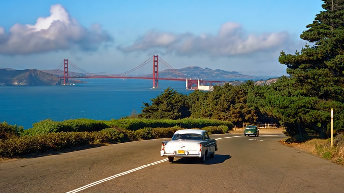 Golden Gate Bridge and Vintage Cars on a Coastal Road