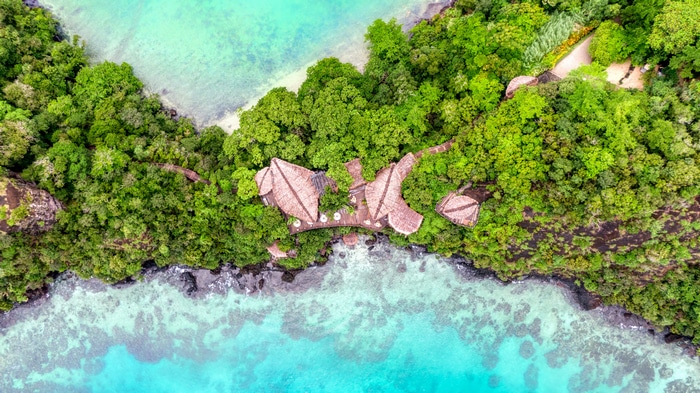 Aerial view of a resort in Fiji surrounded by forest and water