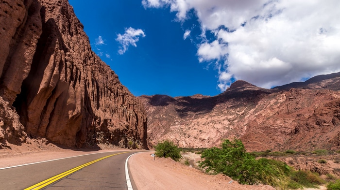 Road through a rocky mountain landscape under a blue sky