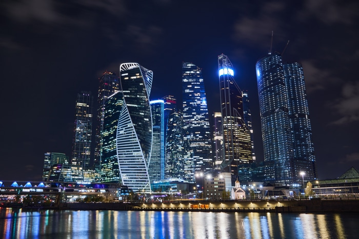 Moscow City skyscrapers at night with river reflection