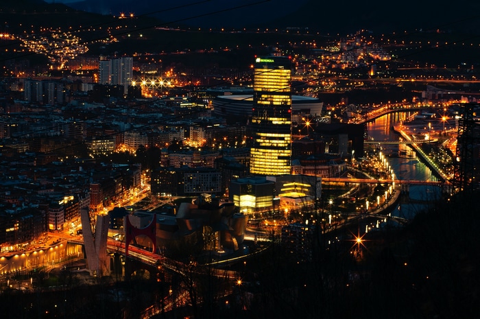 Bilbao cityscape at night with river and skyscrapers