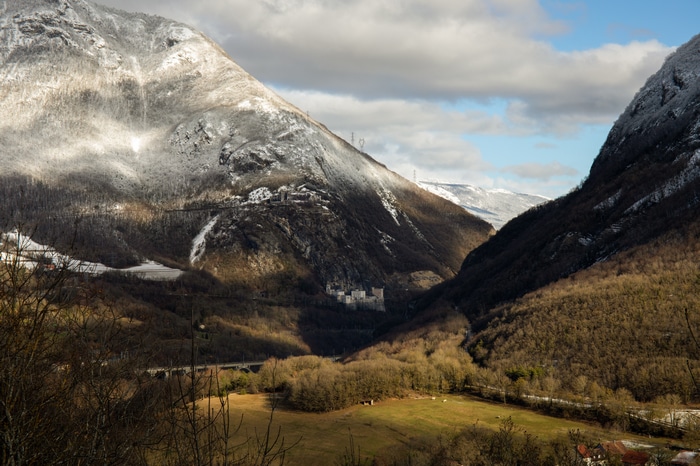 Snow-covered mountains and a valley with a castle in France