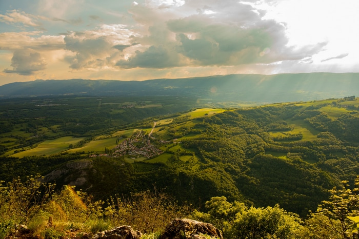 Village in a valley in France with mountains and clouds