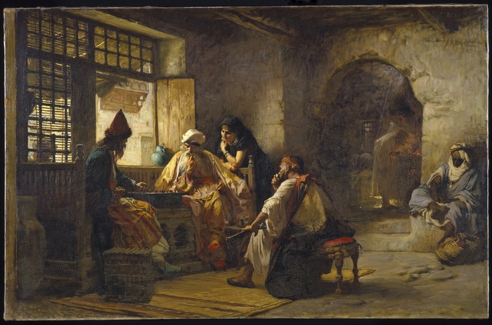 Men playing a board game in a Middle Eastern interior