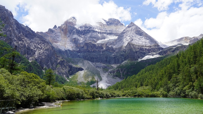 4K mountain lake with snow-capped peaks and green trees