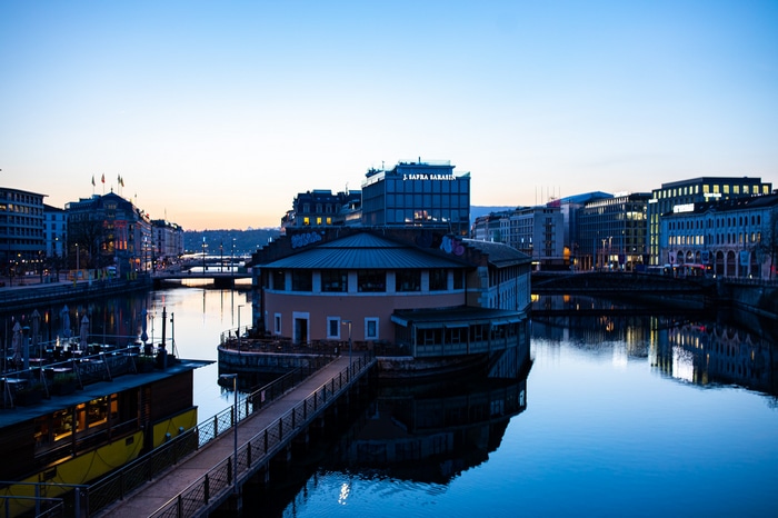 Geneva cityscape with buildings and river at dusk