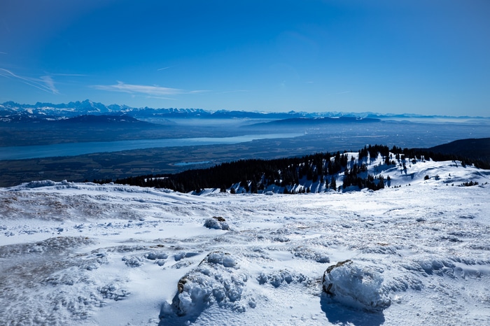 Snowy mountain landscape overlooking a lake and distant mountains