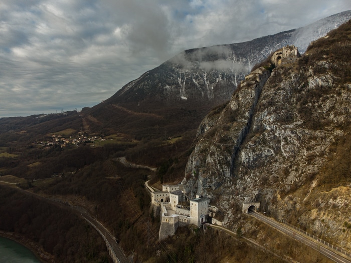 Fortifications on a rocky mountain slope with a road and tunnels