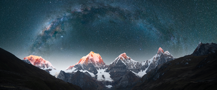 Milky Way over snow-capped mountains at night