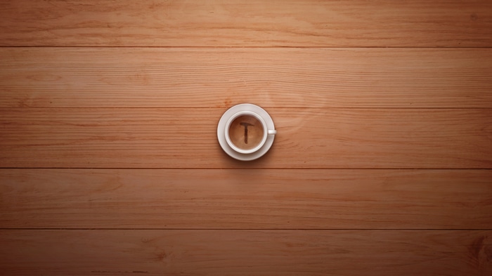 Coffee cup with hammer logo on wood