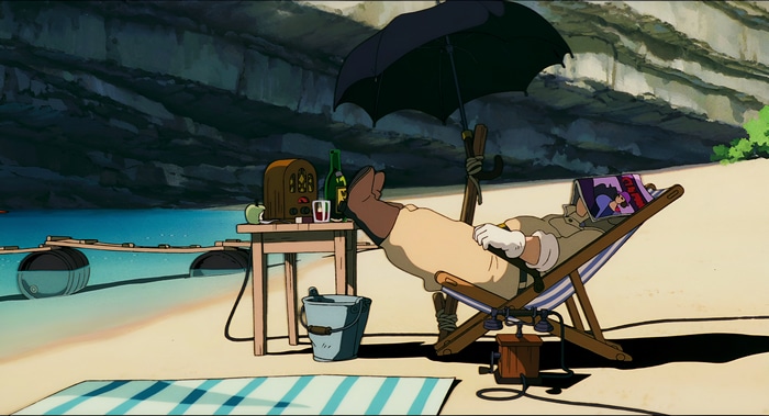 Porco Rosso relaxing on a beach with an umbrella