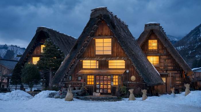 Traditional Japanese houses with thatched roofs in snow