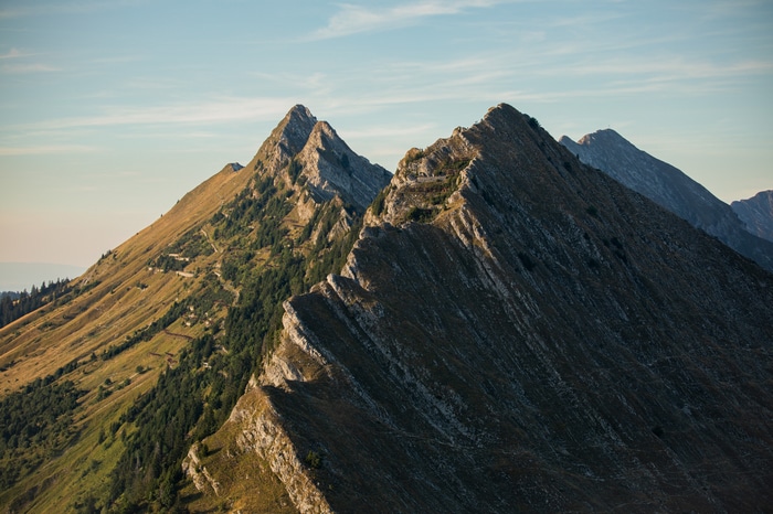 Jagged mountain ridges with trees and a hiking path