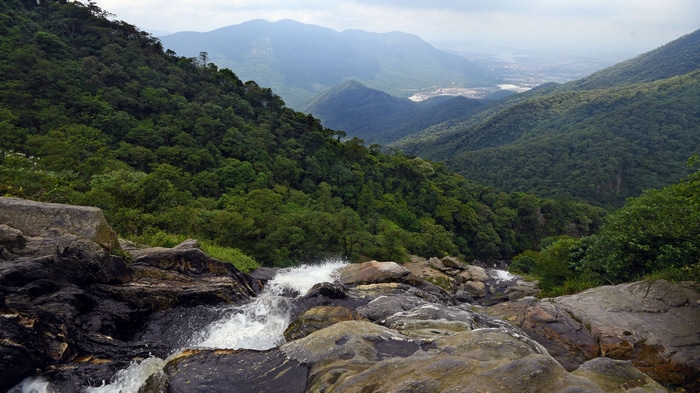 4K waterfall flowing over rocks in a mountain landscape