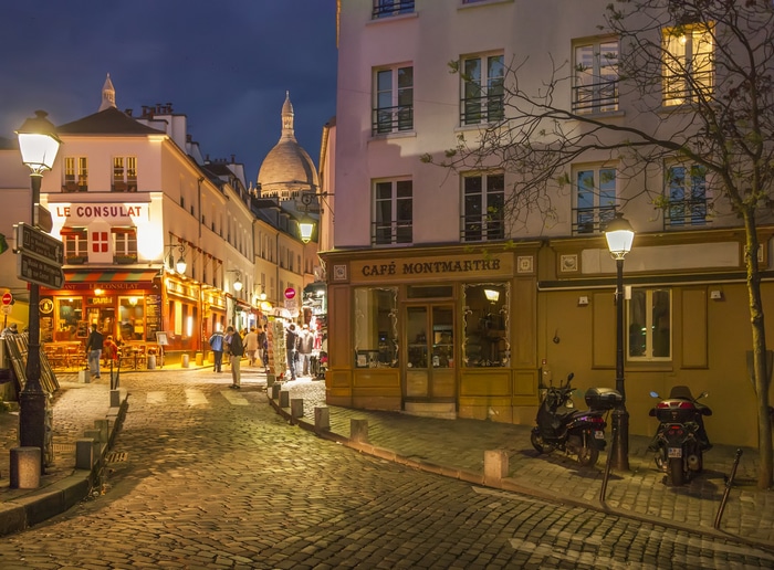 Montmartre street at night with Sacre-Coeur in Paris