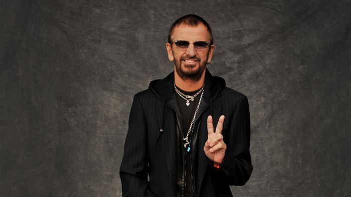 Ringo Starr wearing sunglasses and a suit