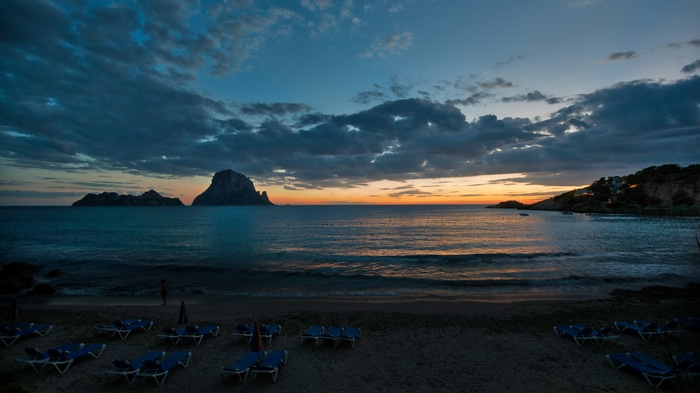 Ibiza sunset over the sea with clouds and beach